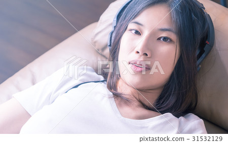 Sexy Asian girl is listening to music on sofa 31532129