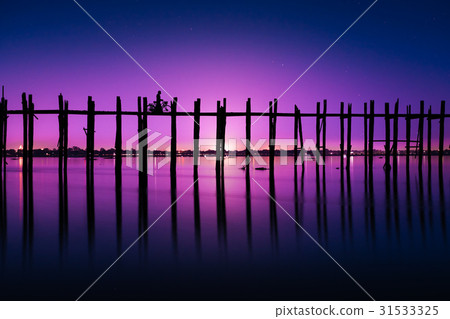 Silhouetted person with a bike on U Bein Bridge 31533325