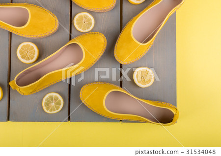Yellow espadrilles shoes near slices of lemon on 31534048