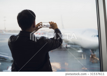 traveler with mobile phone at the airport taking traveler with mobile phone at the airport taking 31537611
