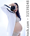 Pregnant asian woman standing and holding camera  31539248