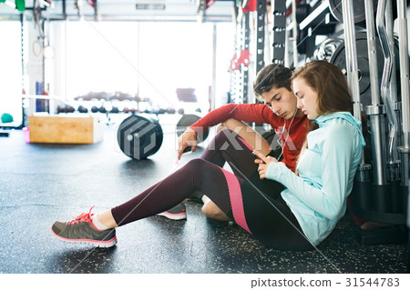 Fit couple in modern crossfit gym with smartphone. 31544783