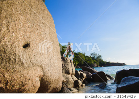 Women is standing on a rock on the beach Women is standing on a rock on the beach 31549429