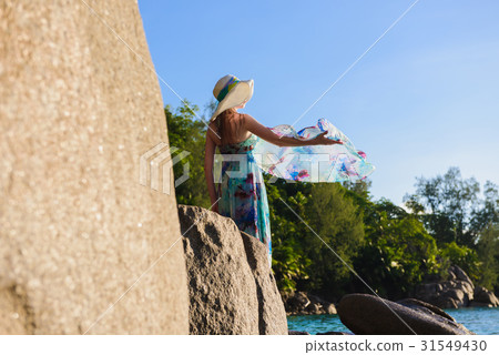 Women is standing on a rock on the beach Women is standing on a rock on the beach 31549430