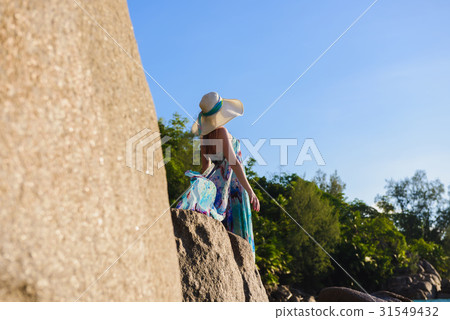 Women is standing on a rock on the beach Women is standing on a rock on the beach 31549432