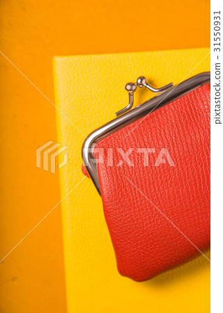 Orange purse with notebook on bright background Orange purse with notebook on bright background 31550931