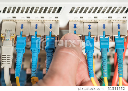 Hand plugs the connector into internet hub 31551352