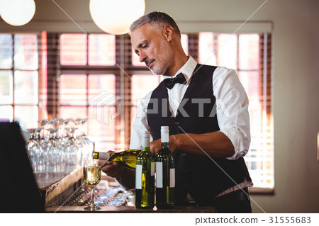 Bartender pouring red wine in a glass 31555683