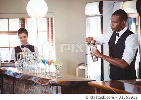 Bartender mixing a cocktail drink in cocktail shaker Bartender mixing a cocktail drink in cocktail shaker 31555912