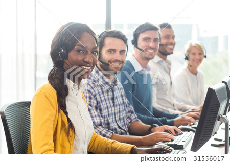 Team of colleagues working at their desk with headset 31556017
