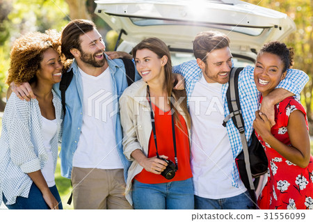 Happy friends standing with arm around in park Happy friends standing with arm around in park 31556099