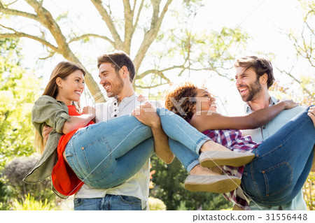 Man giving piggyback to woman while having glass of beer 31556448