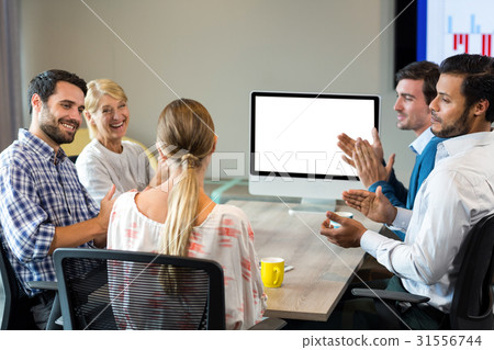 Coworkers applauding a colleague during a video conference 31556744