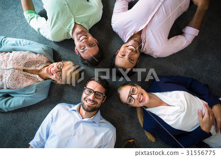 Business team lying on the floor with head together 31556775