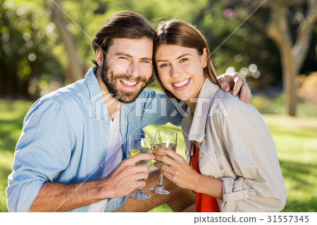 Portrait of couple toasting glasses of wine 31557345