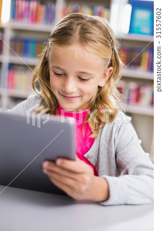 Schoolgirl using digital tablet in library Schoolgirl using digital tablet in library 31557602