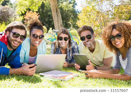 圖庫照片: group of friends using laptop, mobile phone and