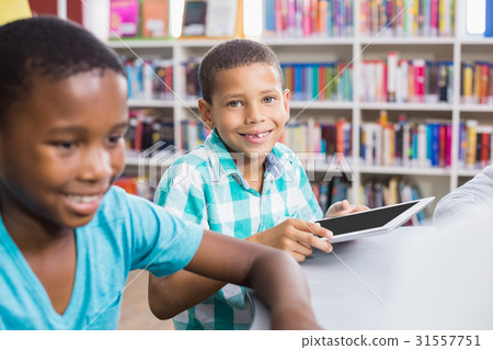Kids using digital tablet in library Kids using digital tablet in library 31557751