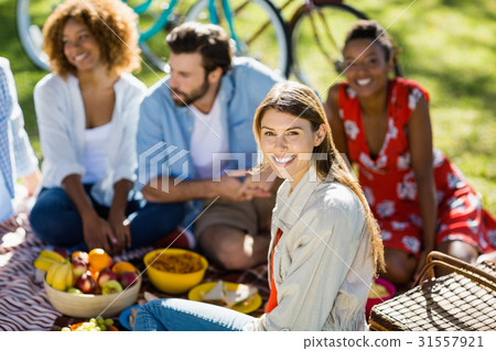 Woman sitting with her friends in park 31557921