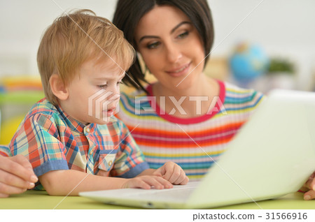 Mother and son using modern laptop Mother and son using modern laptop 31566916