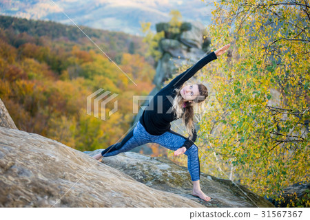Woman is practicing yoga on the top of mountain Woman is practicing yoga on the top of mountain 31567367