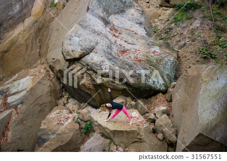 Woman is practicing yoga on the top of mountain 31567551