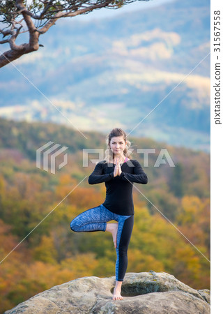 Woman is practicing yoga on the top of mountain 31567558