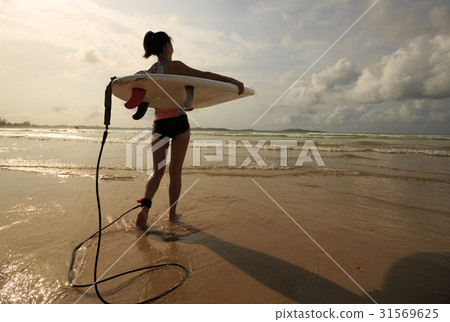 young woman surfer with surfboard ready to surf 31569625