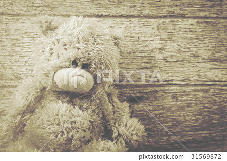 Cute teddy bear on brown wooden background Cute teddy bear on brown wooden background 31569872