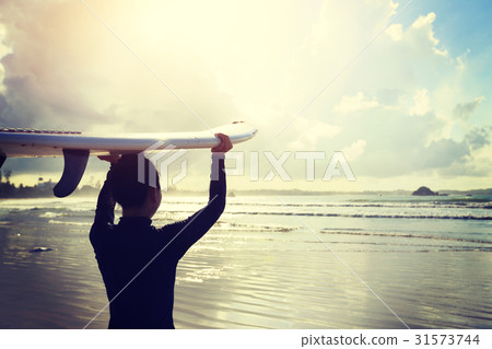 young woman surfer with surfboard ready to surf 31573744