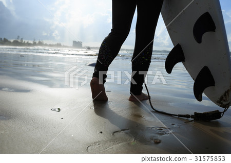 young woman surfer with surfboard ready to surf on a beach 31575853