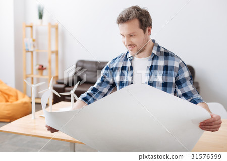 Positive delighted bearded man holding big paper Positive delighted bearded man holding big paper 31576599