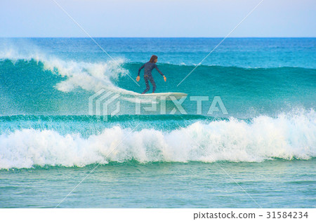 Surfer surfing on a wave 31584234
