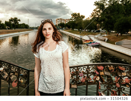 Cute woman on bridge with love locks on fence Cute woman on bridge with love locks on fence 31584326