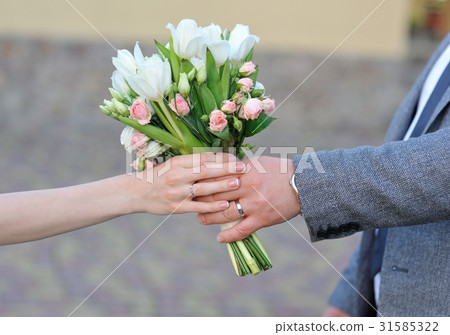 groom gives the bride a wedding bouquet groom gives the bride a wedding bouquet 31585322