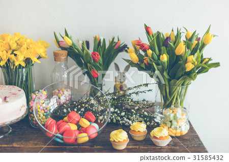 Bright macaroons and cupcakes on a wooden table Bright macaroons and cupcakes on a wooden table 31585432