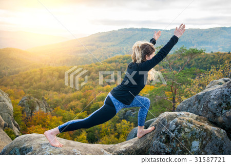 Woman practicing yoga on the top of the mountain Woman practicing yoga on the top of the mountain 31587721