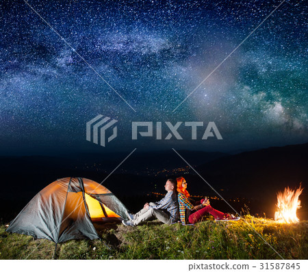 Tourists in camping at night against starry sky 31587845