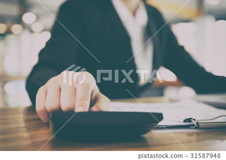 businesswoman using calculator at workplace. young businesswoman using calculator at workplace. young 31587948