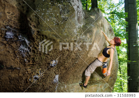Female climber climbing on a rocky wall Female climber climbing on a rocky wall 31588993