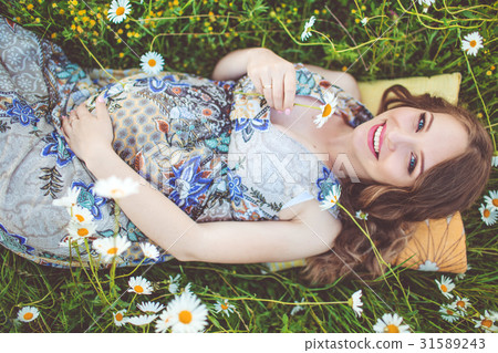 Beautiful pregnant smiling woman lying in the Beautiful pregnant smiling woman lying in the 31589243