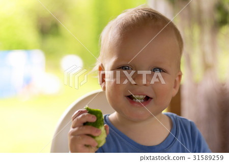 Adorable infant kid with a cucumber in his hand Adorable infant kid with a cucumber in his hand 31589259