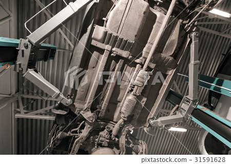 Detail of lifted automobile at repair service 31591628