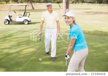 Portrait of confident golfer woman by man 31594429