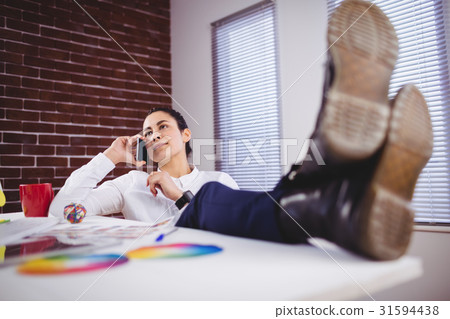 Young woman talking on phone in office 31594438