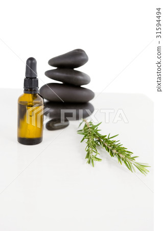 Aromatherapy oil with rosemary and pebbles Aromatherapy oil with rosemary and pebbles 31594494