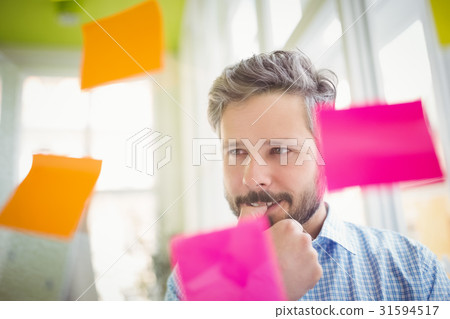 Thoughtful businessman looking at adhesive notes 31594517