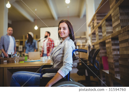 Businesswoman on wheelchair by desk 31594760