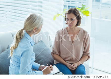 Upset woman talking to therapist 31595214