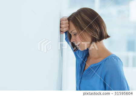 Side view of sad woman by wall 31595604